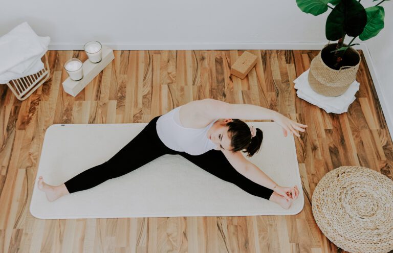 Eine Frau versucht sich beim Yoga zu dehnen sich